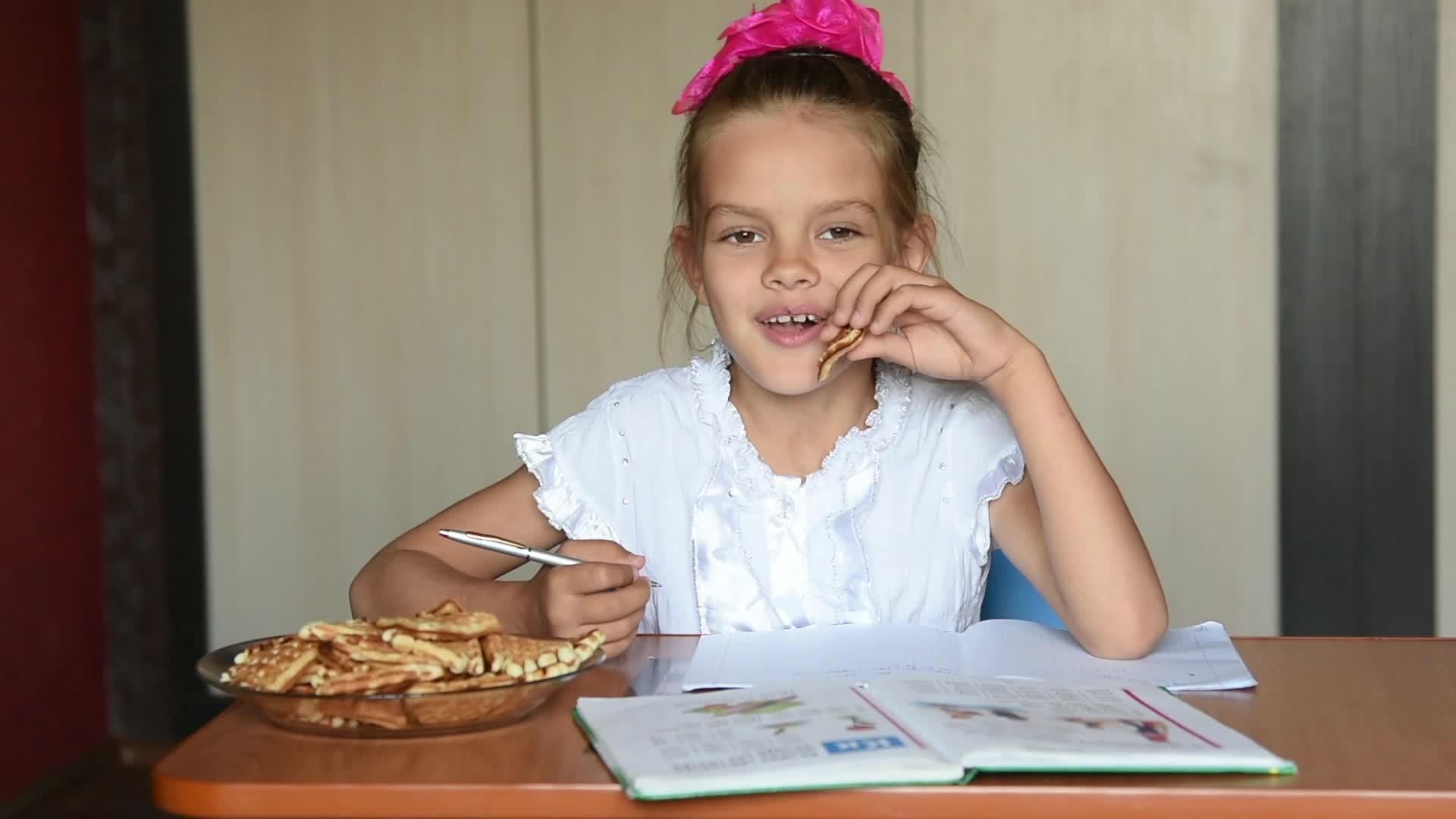 7岁的女孩做作业吃点心饼干视频的预览图