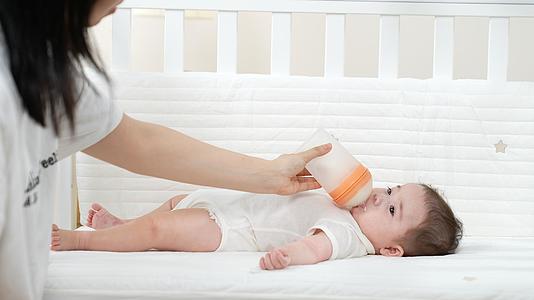 婴儿躺在婴儿床上喝牛奶视频的预览图