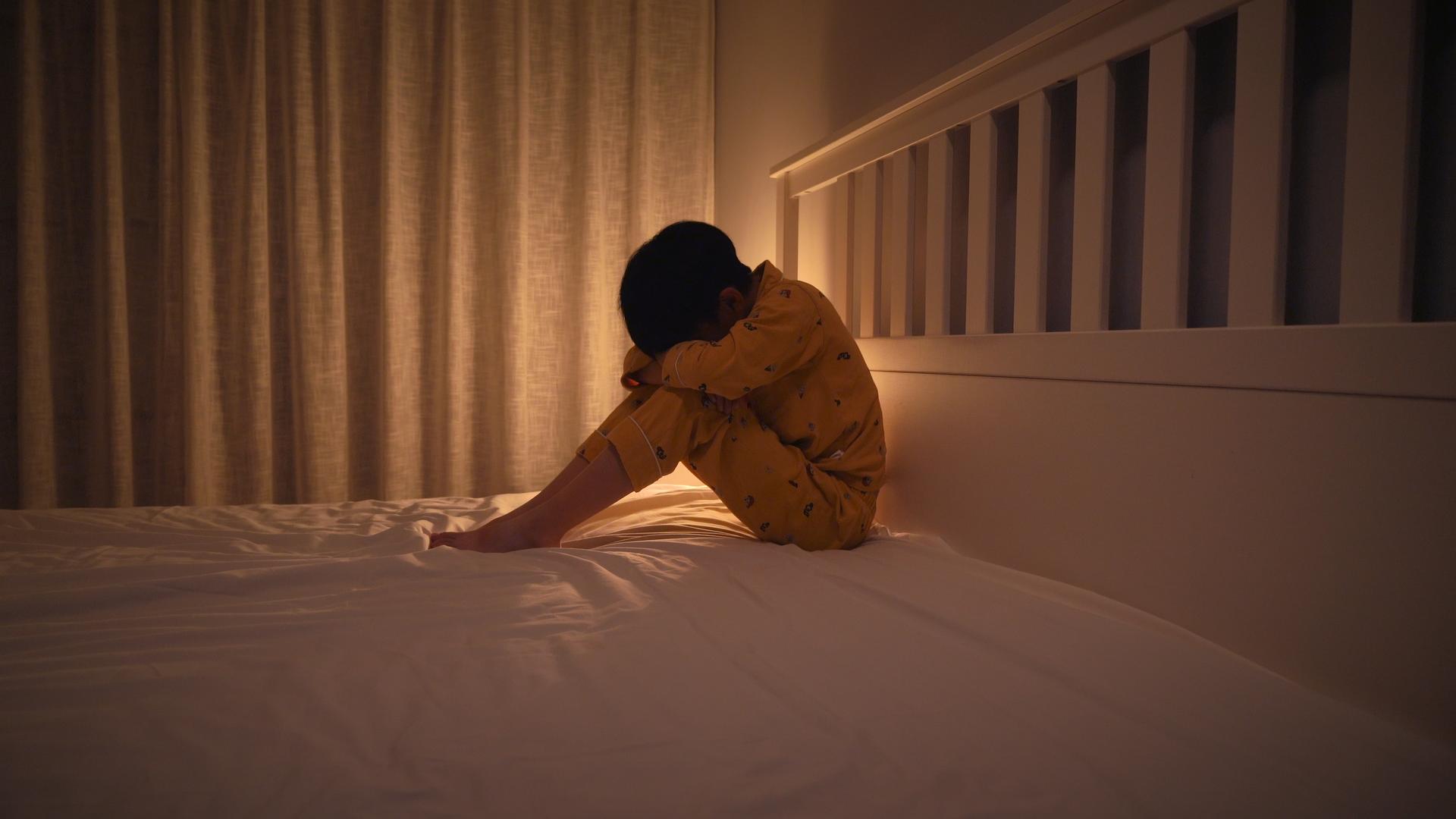 深夜坐在床边哭泣的小男孩视频的预览图