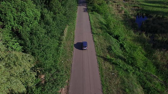在农村道路上驾驶无人驾驶越野车穿过绿林视频的预览图