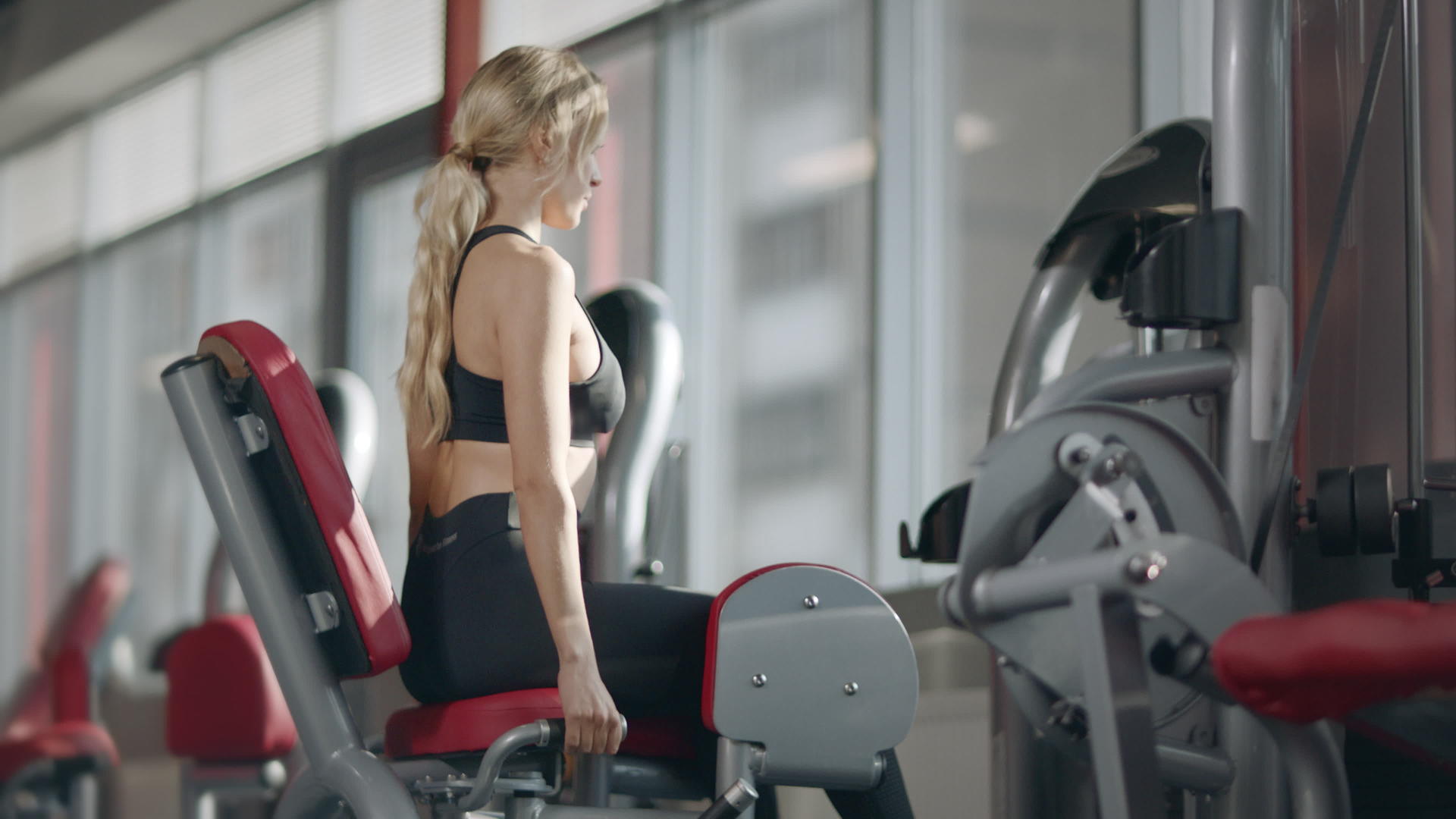 在现代健身房运动模拟器上做健身运动的女性视频的预览图