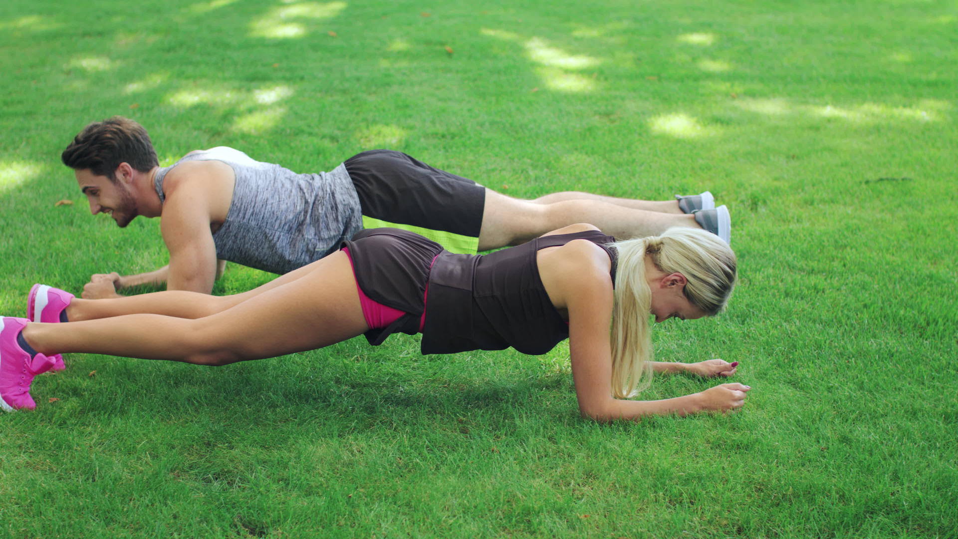 男女在夏季公园草坪上训练健康夫妇视频的预览图