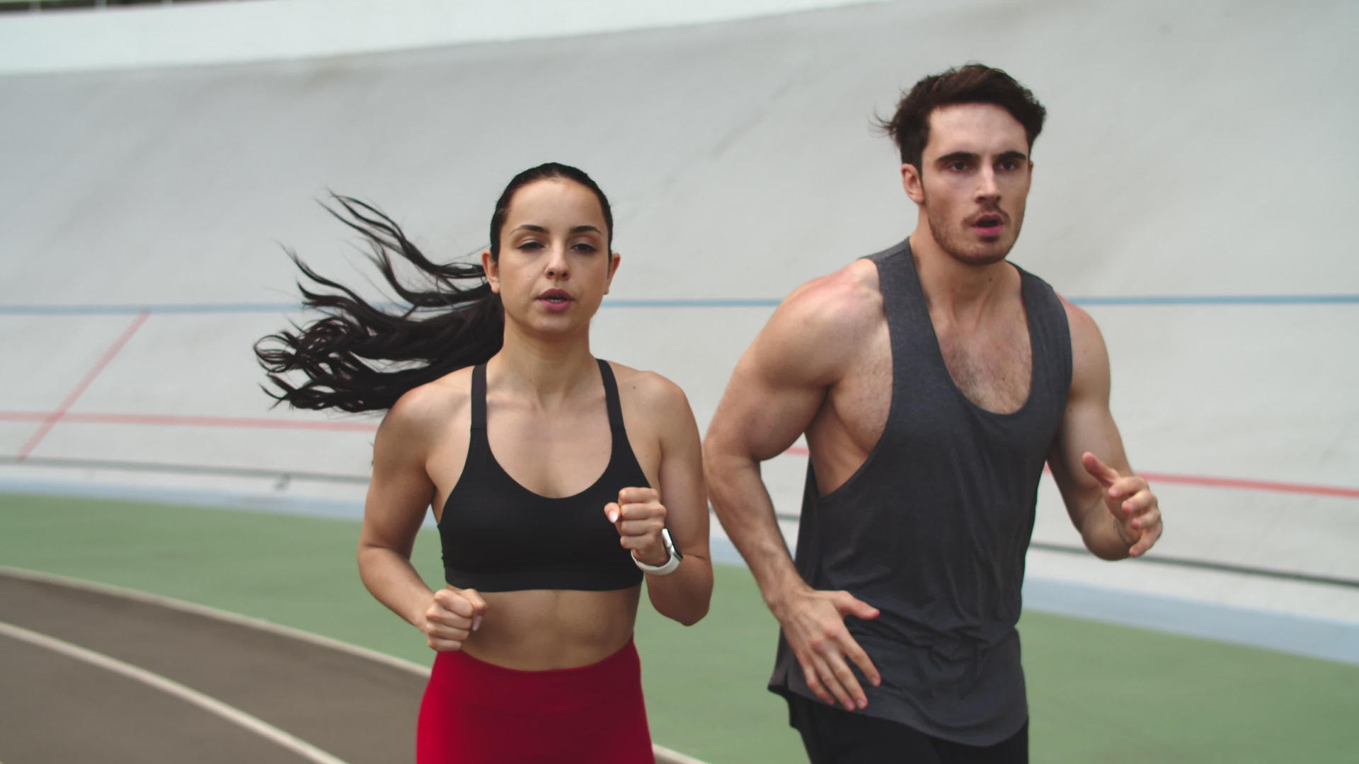 健身夫妇在田径赛道上跑步视频的预览图