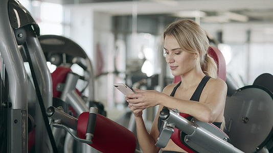 体操馆用手机放松体操运动的女性视频的预览图