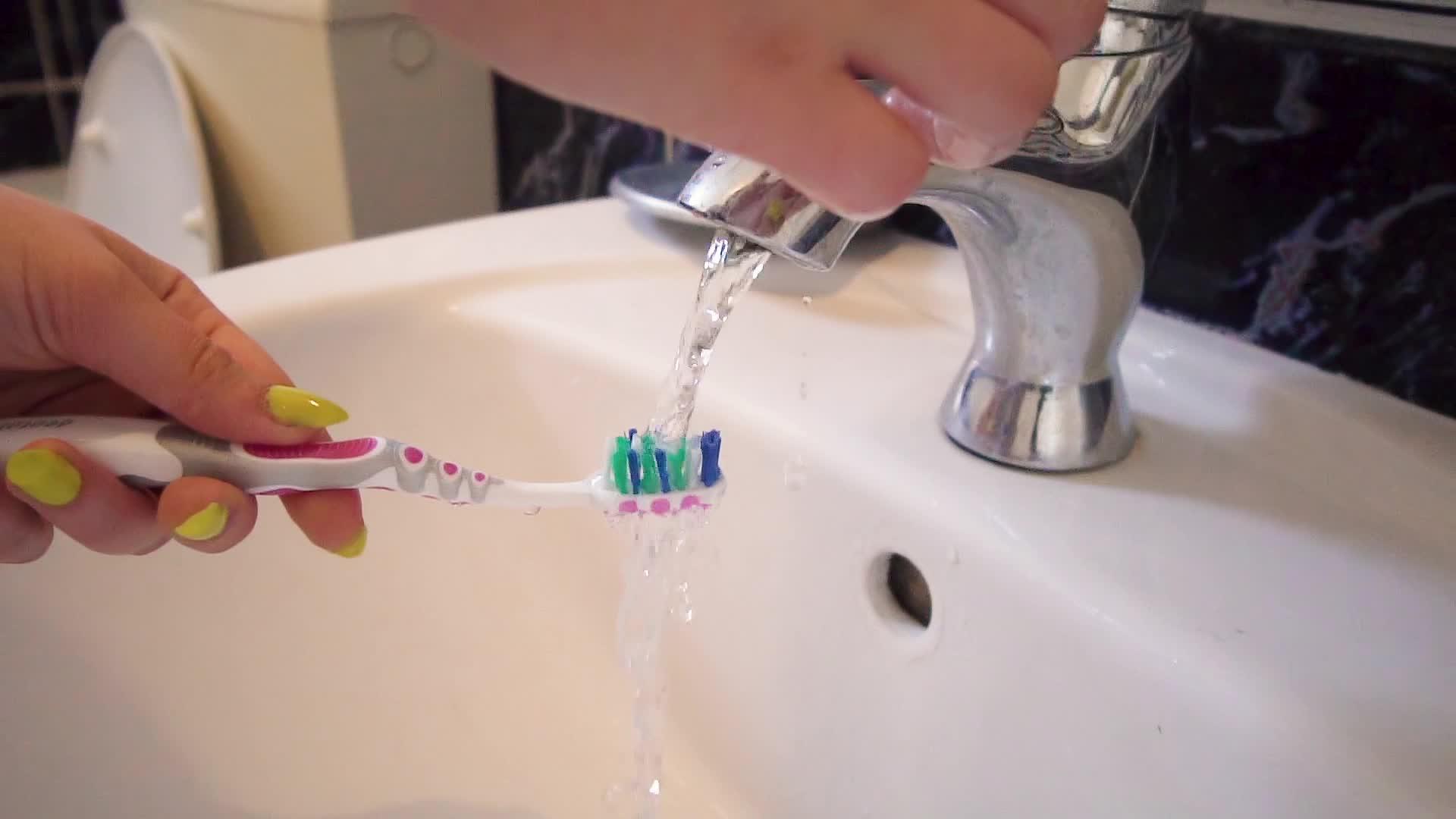 清洁刷牙刷在干净的白色水槽和自来水中慢动作视频的预览图