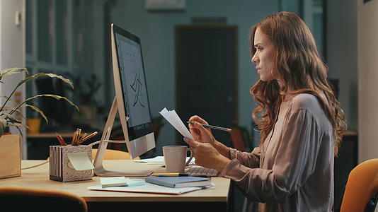 关键的商业女性在晚上在电脑屏幕上制作财务图表视频的预览图
