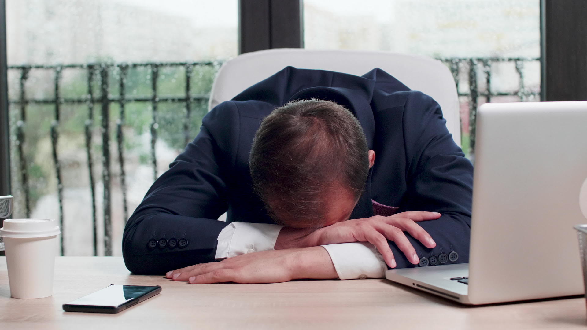 疲惫的商人睡在办公桌上近距离拍摄视频的预览图