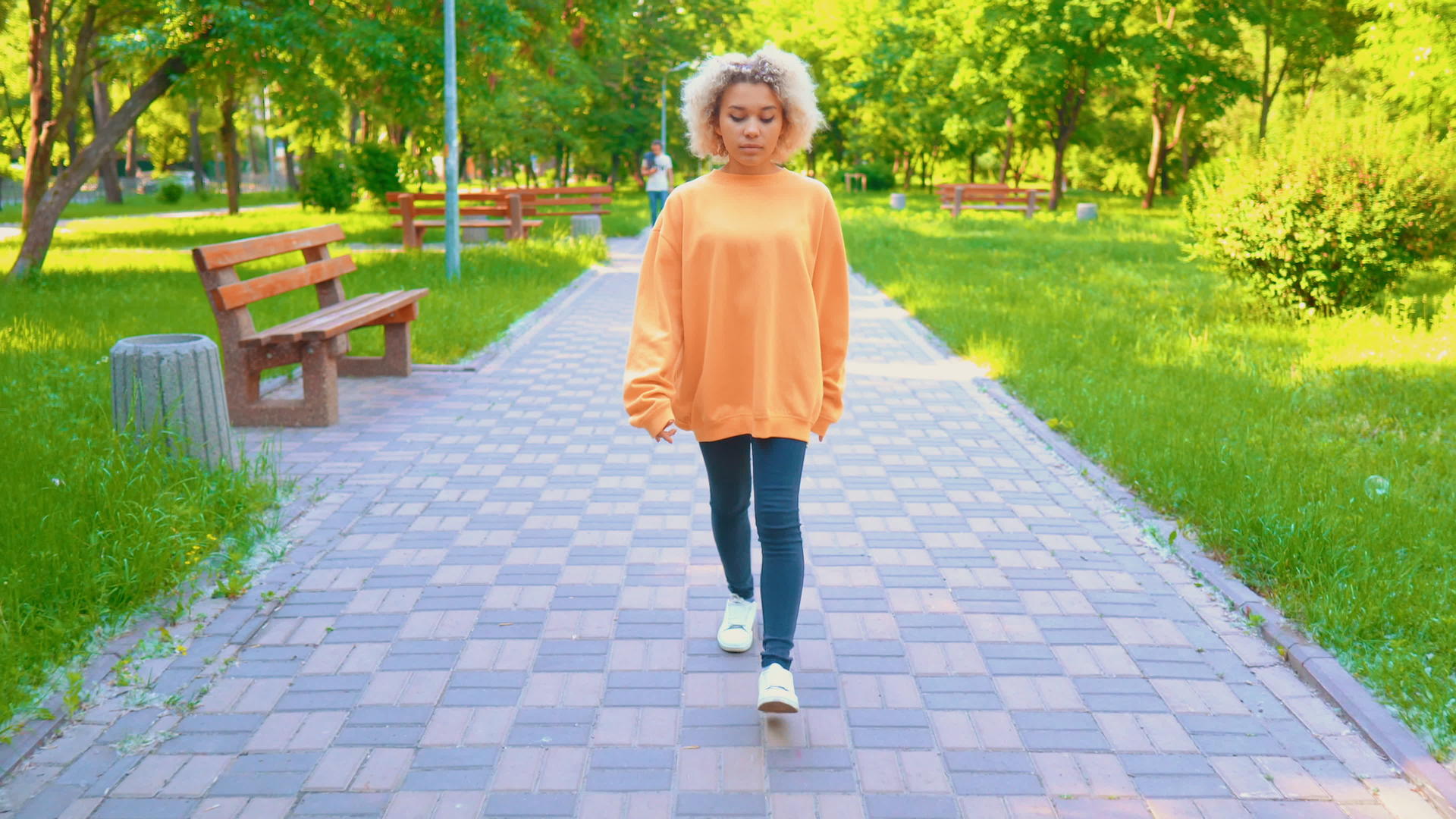 女孩穿着黄色毛衣在公园里散步视频的预览图