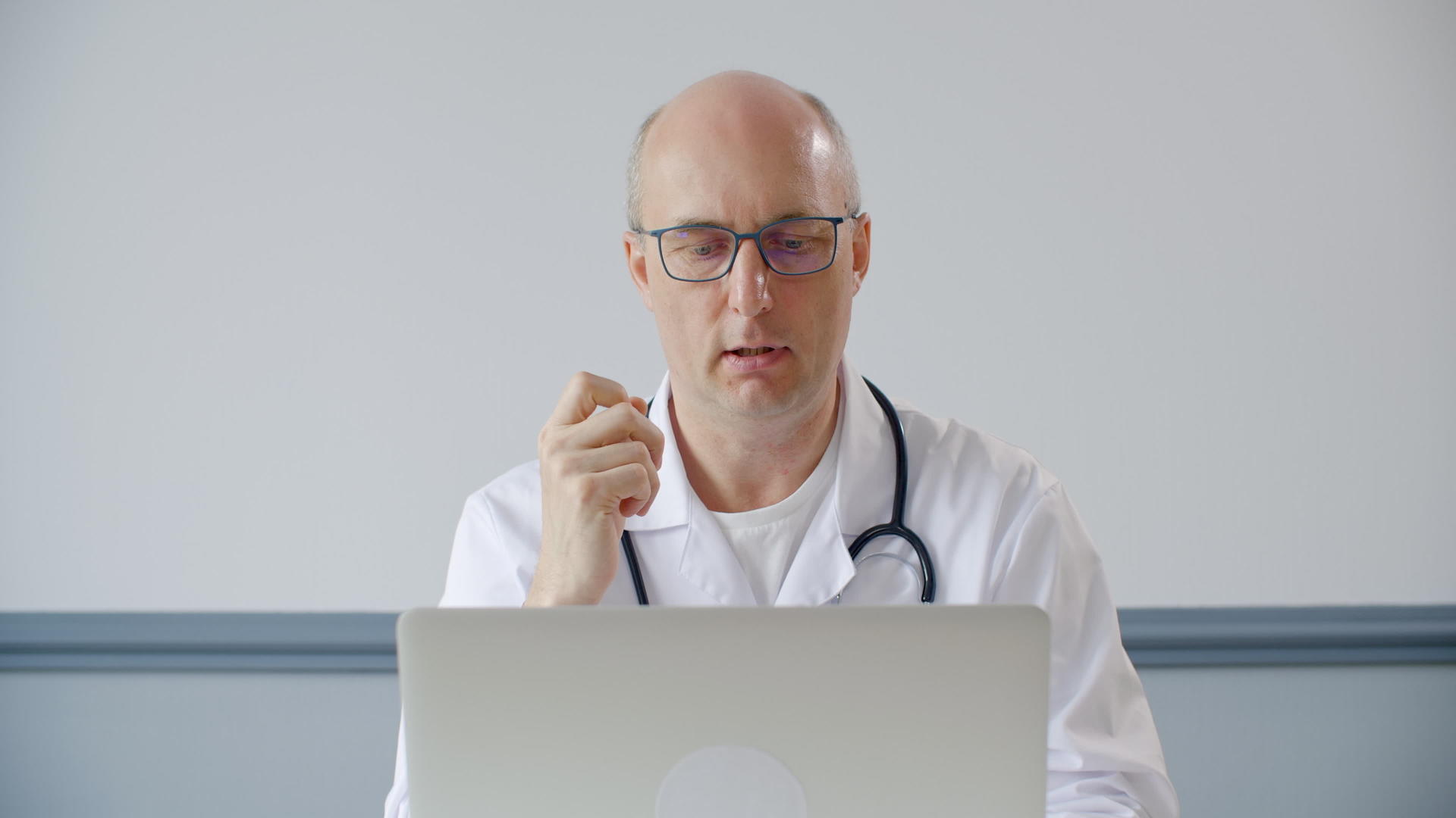 专业男医生用笔剪贴板讨论诊断视频的预览图