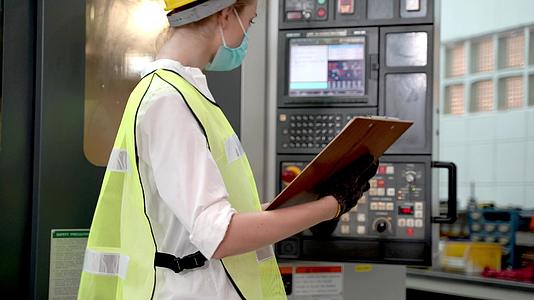工厂职业经理妇女用报告纸检查重型机器视频的预览图
