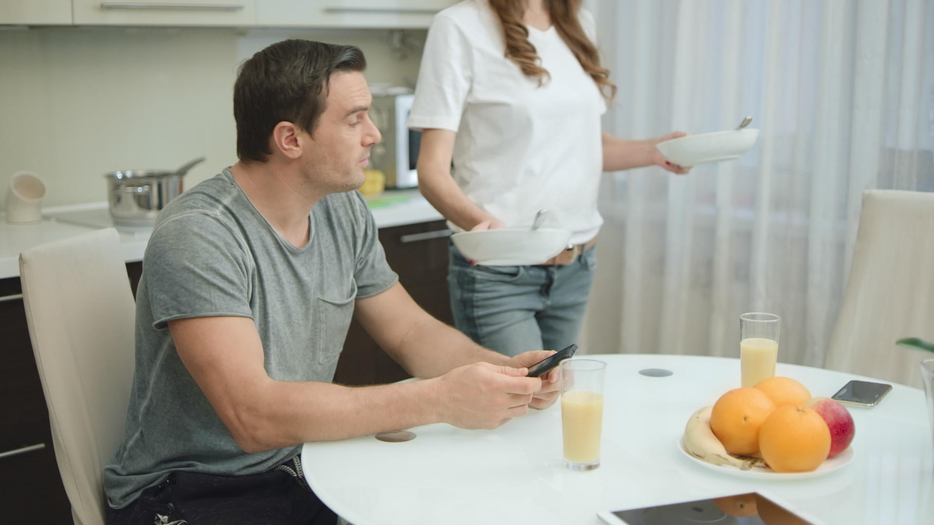 在客厅健康的早餐期间快乐的情侣喝橙汁视频的预览图