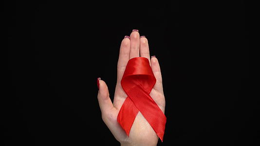 支持世界援助日妇女双手的红色丝带视频的预览图