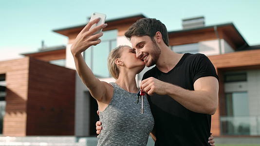 一对快乐的夫妇自拍照片房屋外的房屋钥匙视频的预览图