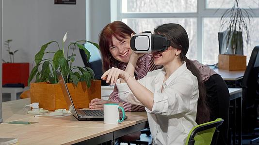 两位女商业同事在工作时尝试VR眼镜视频的预览图