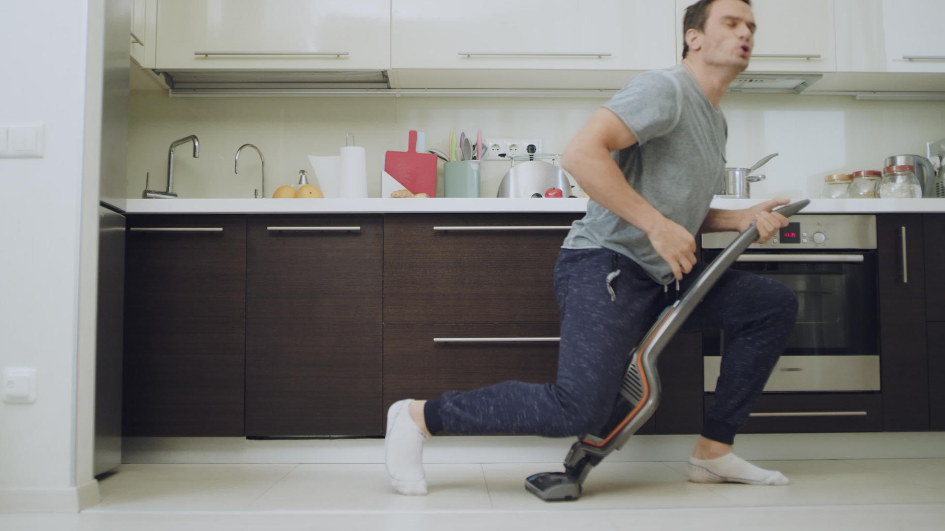 快乐的丈夫在现代厨房打扫地板视频的预览图