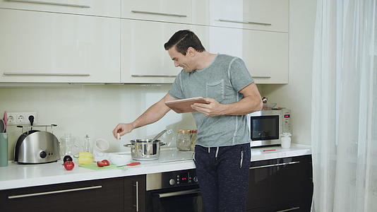 快乐的男人在厨房里做健康的晚餐视频的预览图