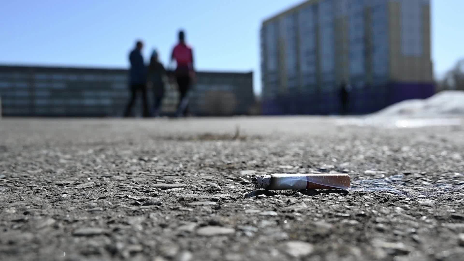 一个废弃的烟头躺在城市体育场的沥青跑道上视频的预览图