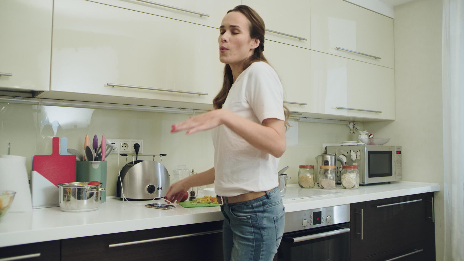 快乐女人在现代厨房跳舞视频的预览图