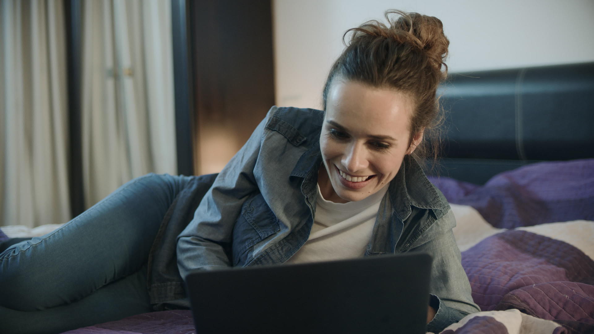 在家里用笔记本电脑微笑的快乐女人视频的预览图
