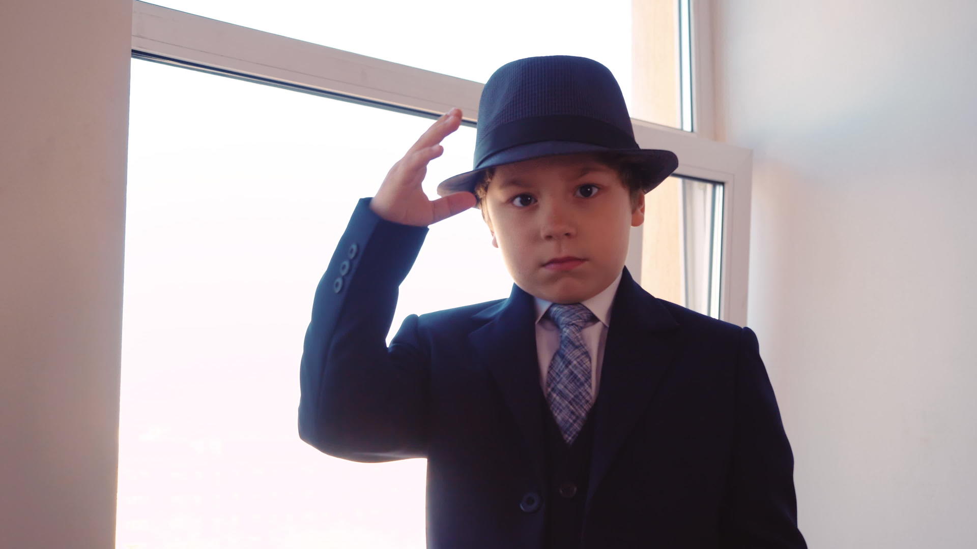 严肃的小男孩穿着西装戴着帽子视频的预览图