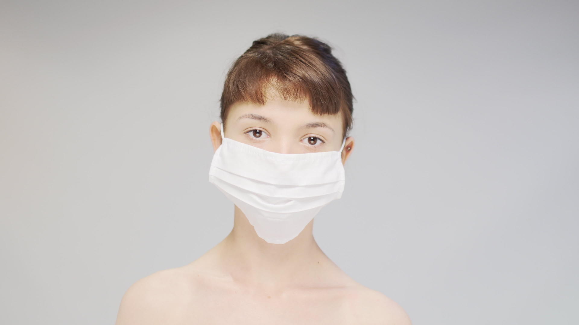一个穿着医用口罩的可爱女孩的视频肖像视频的预览图
