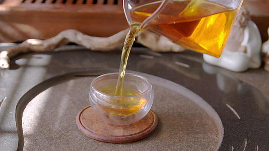 在传统的仪式中将新鲜的热茶从眼镜壶里倒入碗中视频的预览图
