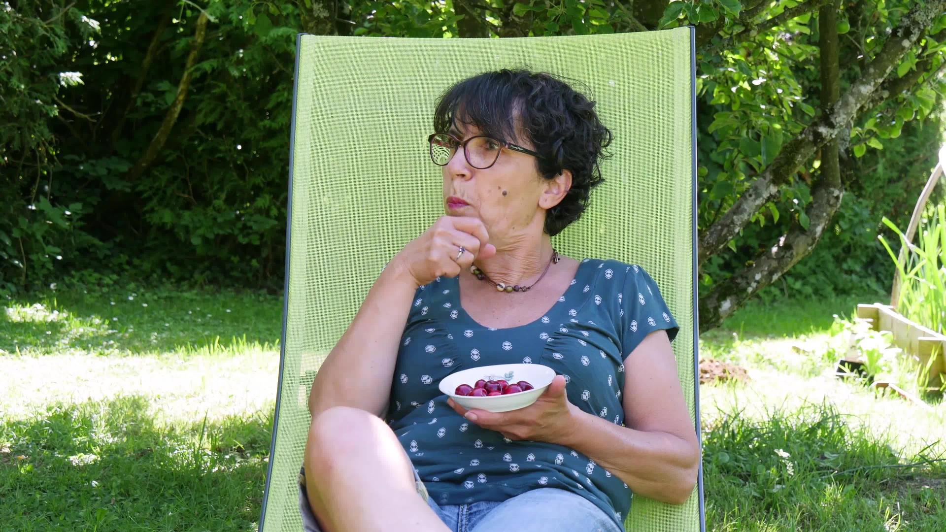 中年妇女在花园里吃樱桃视频的预览图