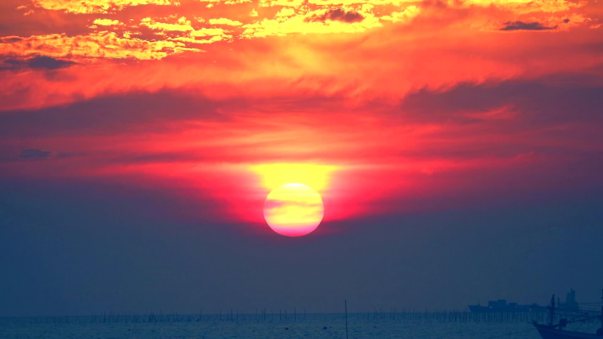 日落时五颜六色的天空和海上的火焰云以及波动的小浪视频的预览图