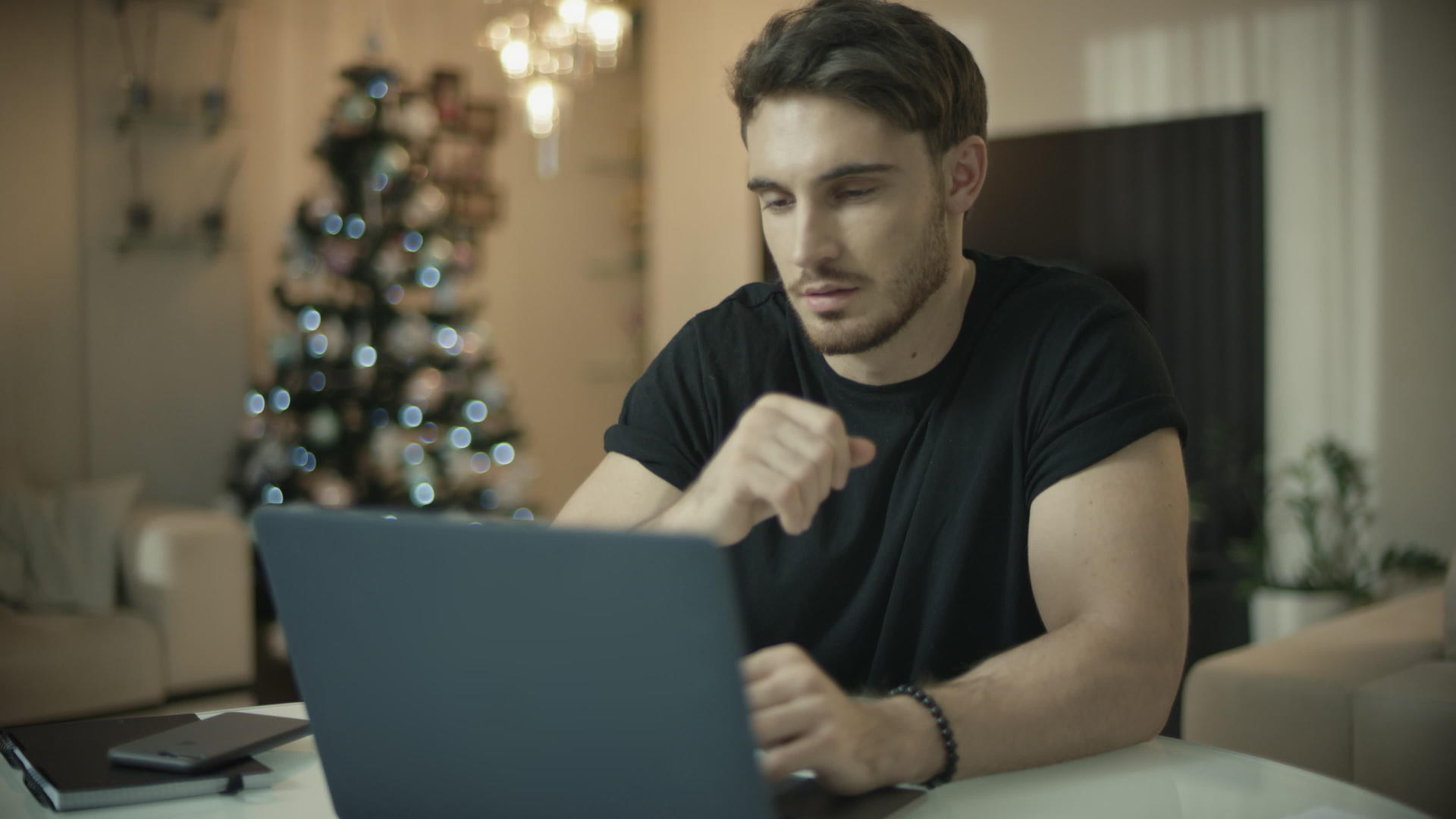 圣诞节期间男子在家使用笔记本电脑视频的预览图