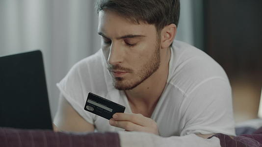 男性使用信用卡在线支付计算机视频的预览图