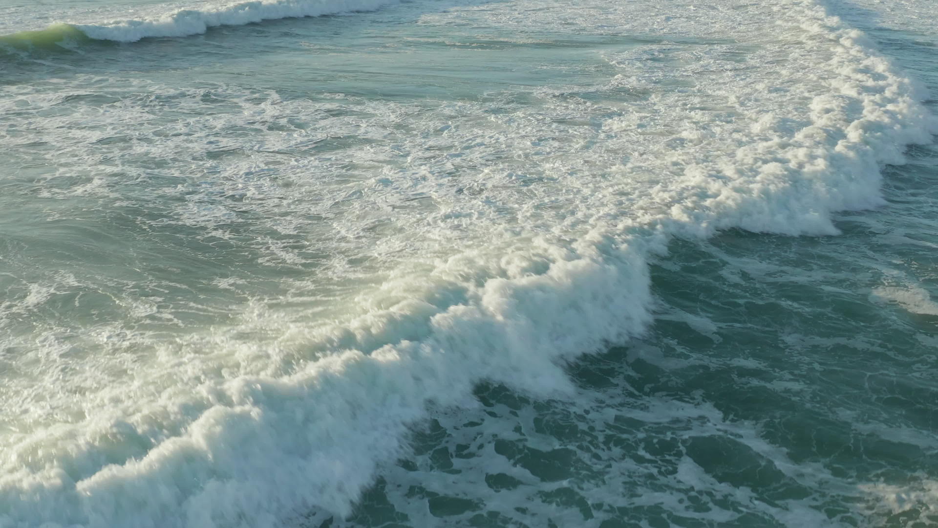 美丽的白色绿色海浪在下午的光线下视频的预览图