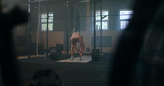 年轻人在健身房做举重运动男人身房做硬拉年轻运动员把杠铃举到胸前男子举重运动员在比赛中举起杠杆视频的预览图