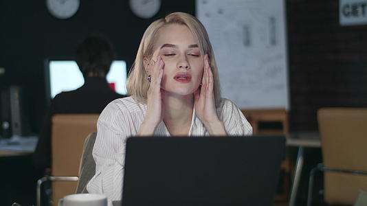 工作女性夜间办公室头痛视频的预览图
