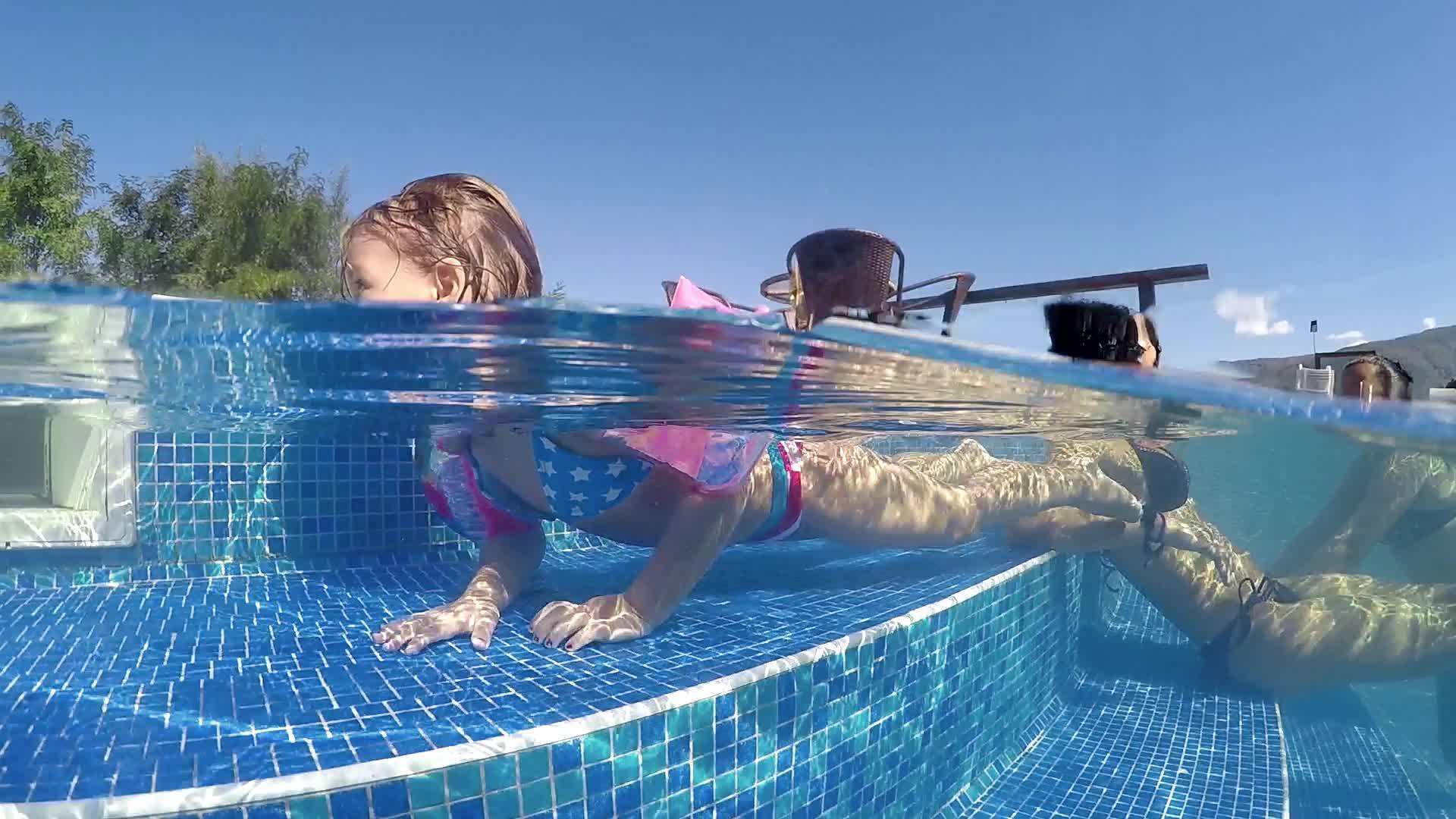 带着胳膊的小女孩在温泉游泳池里玩得很开心视频的预览图