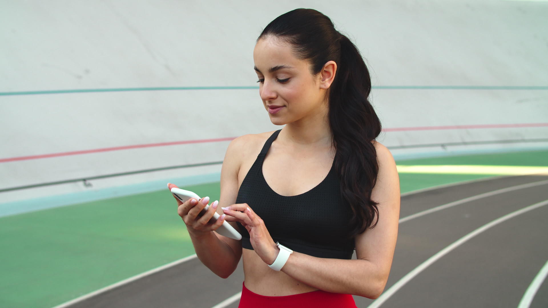 健身女孩肖像在体育场使用电话视频的预览图