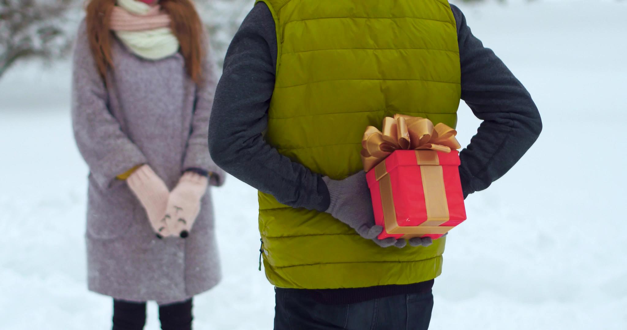快乐的年轻夫妇在冬季公园送礼物视频的预览图