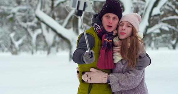快乐的年轻夫妇在冬季公园自拍视频的预览图