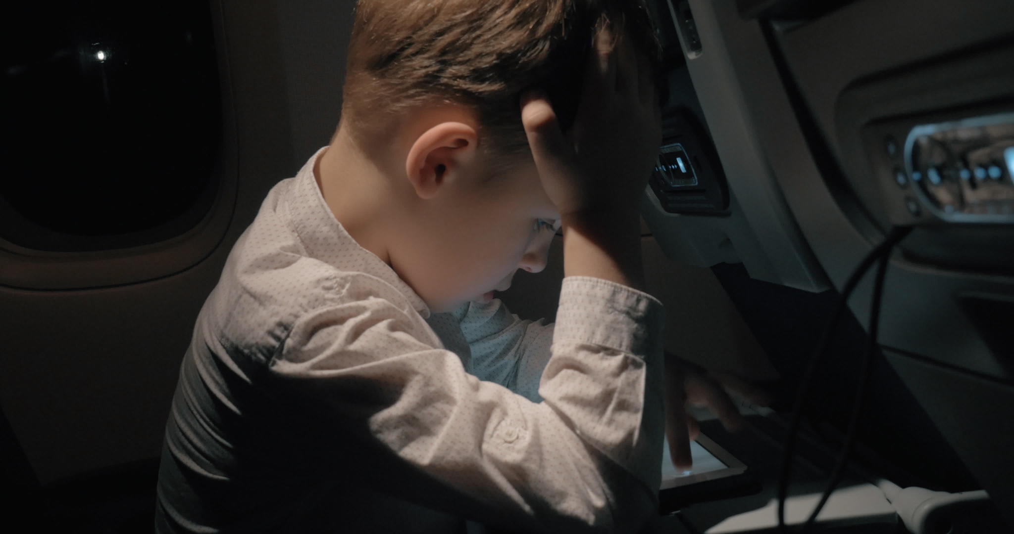 男孩乘飞机旅行在数字平板电脑上下棋视频的预览图