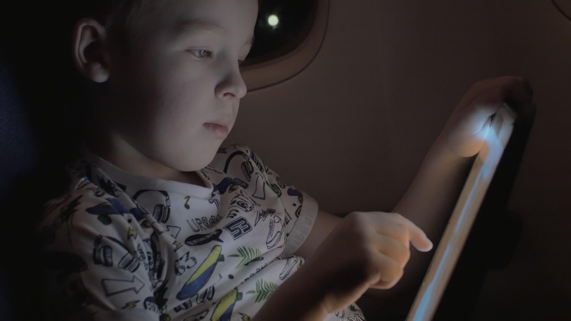 男孩坐飞机在平板电脑上玩游戏视频的预览图
