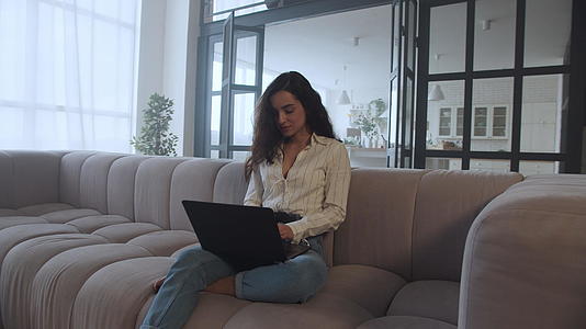 年轻女性在家用笔记本电脑上缓慢移动的肖像视频的预览图