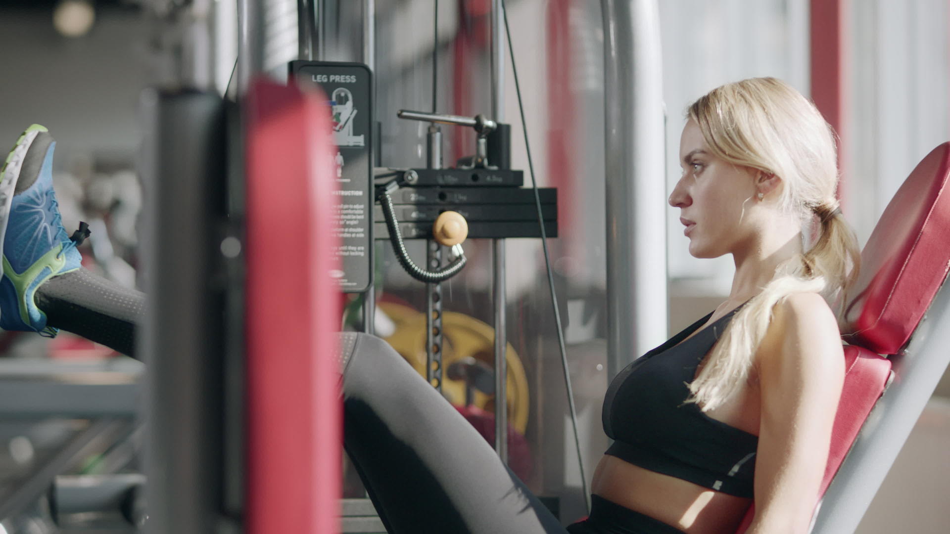在运动俱乐部训练女性的腿在机器上视频的预览图