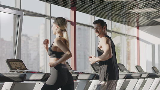 一对夫妇在健身中心的运动机上锻炼视频的预览图