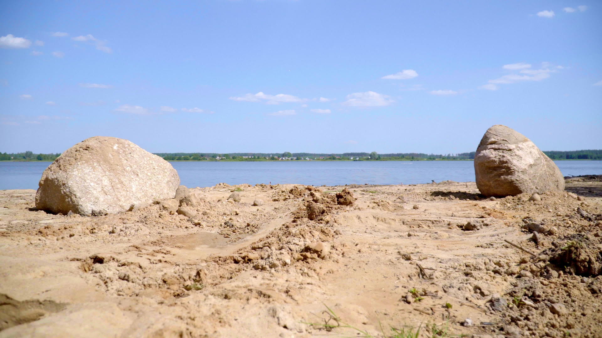 村庄附近湖岸的沙子和巨石视频的预览图