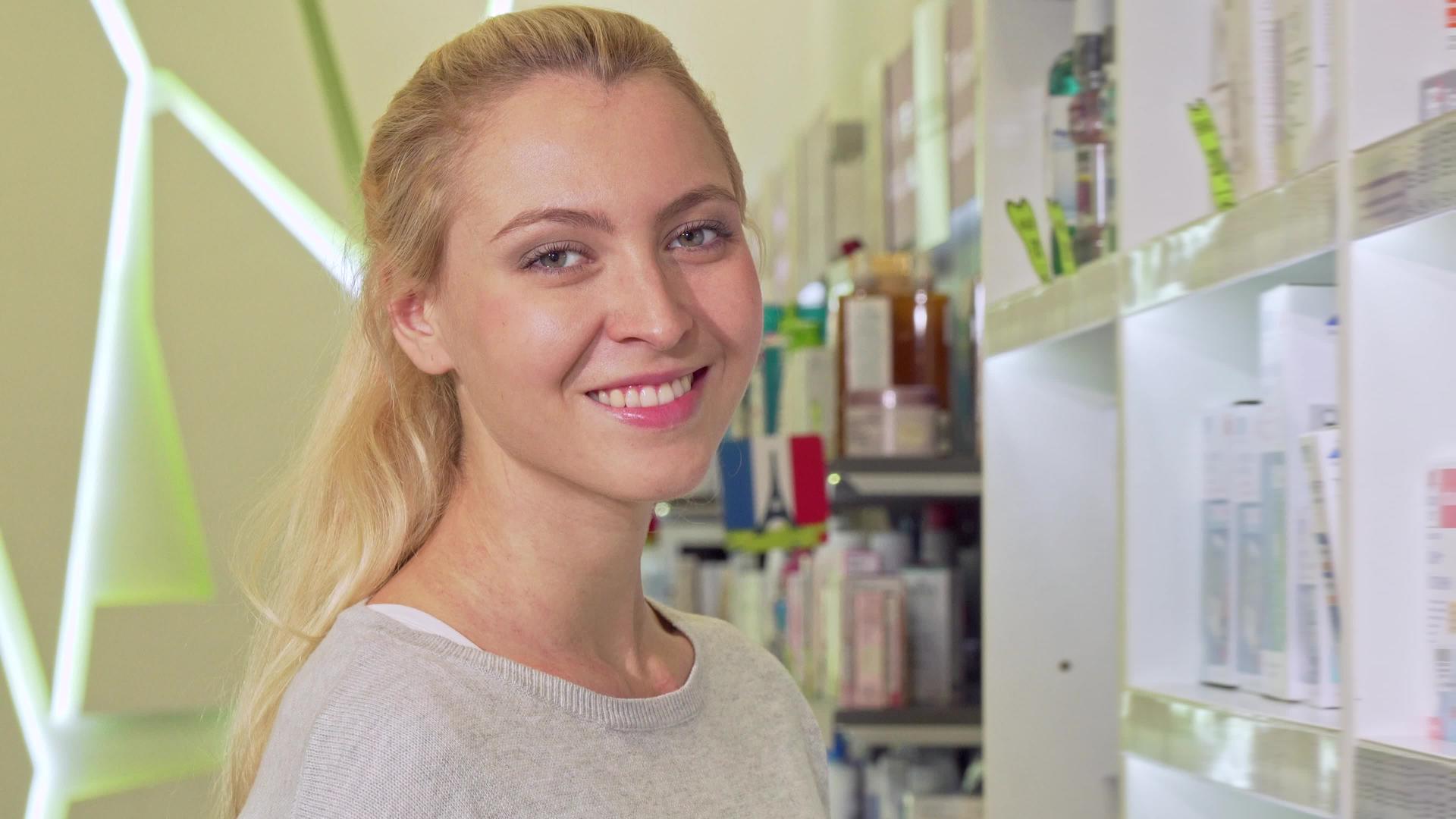 可爱的年轻美女对着镜头微笑在药店购物视频的预览图