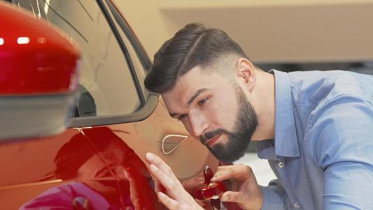 英俊的长胡子男子在经销商检查红色汽车视频的预览图