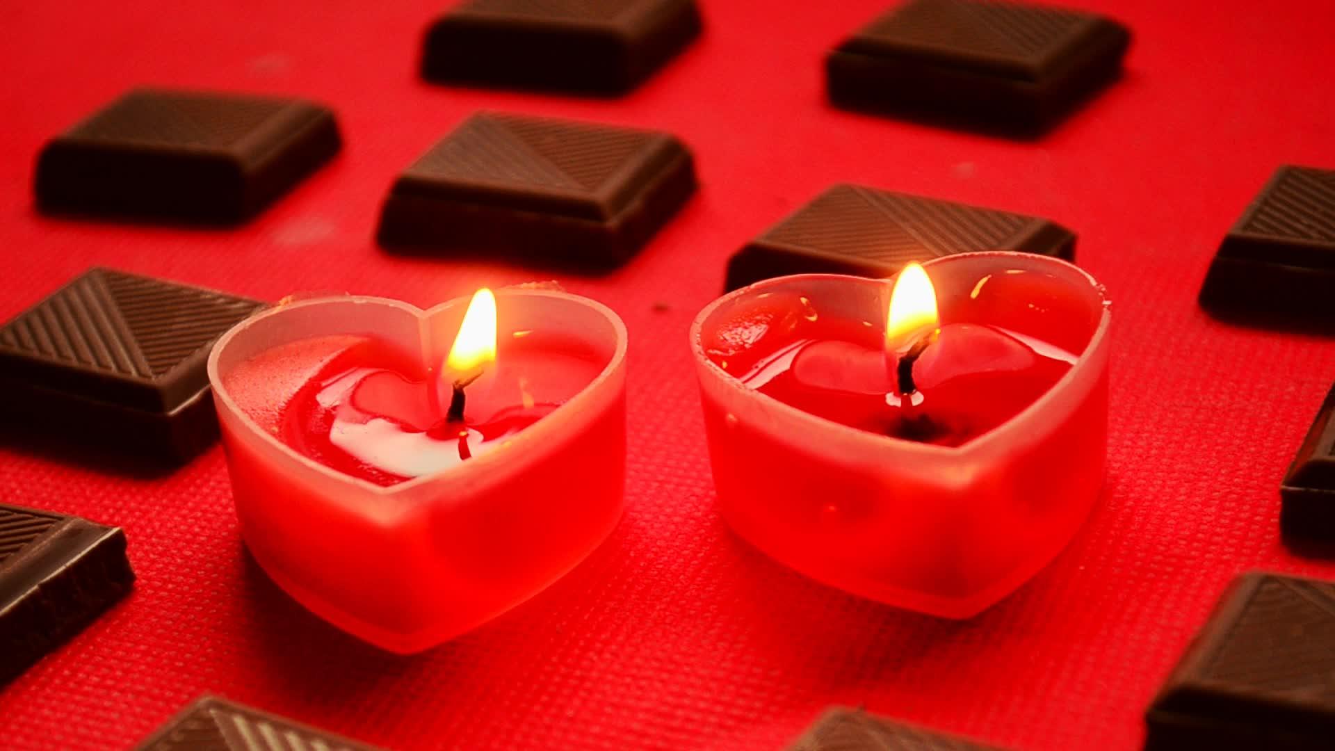 两个燃烧的爱和巧克力块在红色背景下视频的预览图