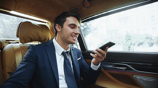 商人在商场和汽车上开心地在智能手机上发短信视频的预览图