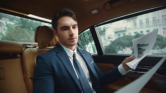 豪华轿车沙龙专注于男性行业阅读文件的肖像视频的预览图