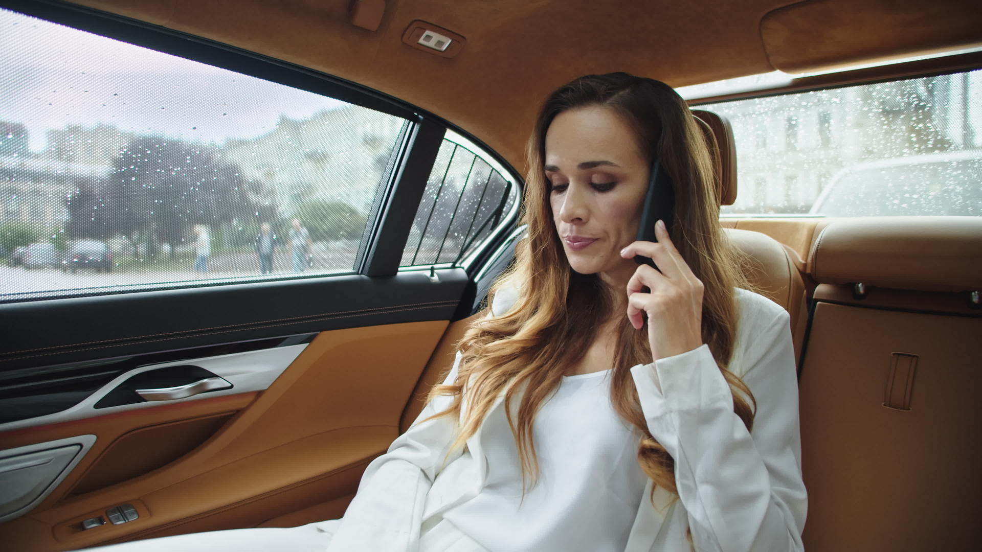 现代冷漠的女商人坐在车后用手机聊天聊天视频的预览图