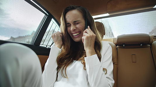 快乐的女商人在现代汽车上用手机聊天视频的预览图